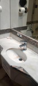 a bathroom with a white sink and a mirror at محبس الجن in Al Khansāk