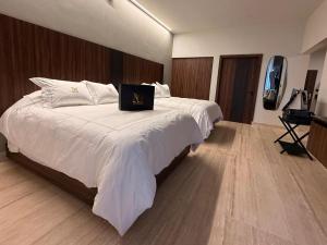 Un dormitorio con una cama con una computadora portátil encima. en Hotel Montessuites, en Bernal
