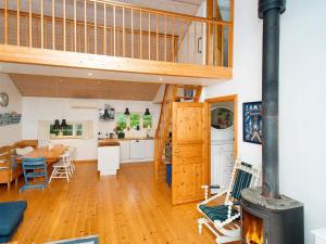 a kitchen and living room with a wood stove at 8 person holiday home in Jægerspris-By Traum in Jægerspris