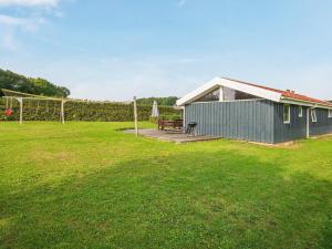 un bâtiment vert avec un banc dans un champ dans l'établissement 10 person holiday home in Sydals, à Sarup