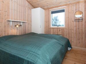 une chambre avec un lit vert dans une pièce en bois dans l'établissement 10 person holiday home in Sydals, à Sarup