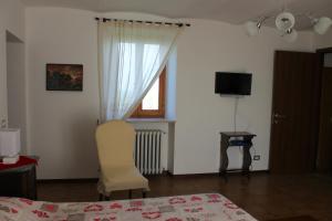 1 dormitorio con 1 cama, 1 silla y 1 ventana en Bed & Breakfast L'Infernot, en Rosignano Monferrato