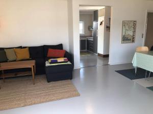 a living room with a black couch and a kitchen at 6 person holiday home in Thyborøn-By Traum in Thyborøn