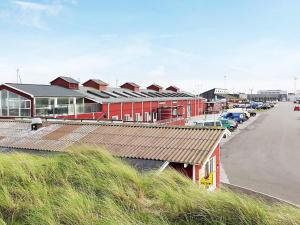 a row of buildings with cars parked in a parking lot at 6 person holiday home in Thyborøn-By Traum in Thyborøn