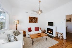 un soggiorno con un divano bianco e un camino di Mygoura Cottage - Charming Country Living in Town a Mudgee