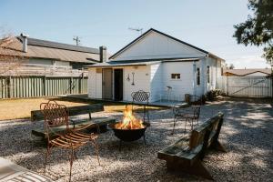 un focolare in un cortile con sedie e un edificio di Mygoura Cottage - Charming Country Living in Town a Mudgee