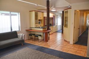 a living room with a couch and a kitchen at The Blue Jem - A central city home away from home! in Napier