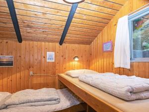 una camera con 2 letti su una parete in legno di Tranquil Cottage Retreat in Lokken-By Traum a Løkken