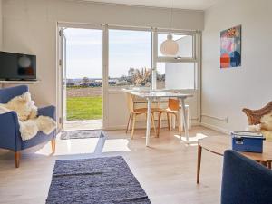 a living room with a table and chairs and a window at Seaside Escape in Sandkas - By Traum Ferienwohnungen in Allinge