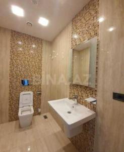 a bathroom with a sink and a toilet and a mirror at HILTON LUXURY of Residence Apartment 5 Stars in Baku