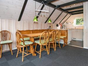 a dining room with a wooden table and chairs at Tranquil Thatched Cottage on Romo-By Traum in Toftum