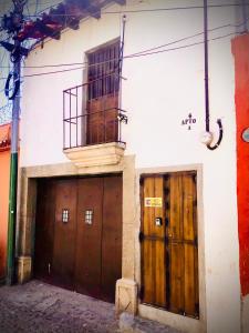 a building with two wooden doors and a balcony at Vintage Apartment with Balcony & Terrace in Antigua Guatemala