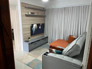 a living room with a couch and a television at Casa de Verão in Florianópolis