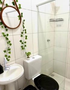 une salle de bains blanche avec toilettes et lavabo dans l'établissement Casa Beira Mar - Vista do Mar pela Janela da Sala, perfeita, em frente à praia da enseada Sesc Bertioga, à Bertioga 23 autres photos