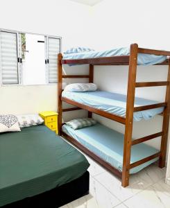 une chambre avec deux lits superposés et une fenêtre dans l'établissement Casa Beira Mar - Vista do Mar pela Janela da Sala, perfeita, em frente à praia da enseada Sesc Bertioga, à Bertioga
