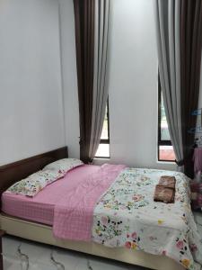a bed sitting in a bedroom with a window at Seri Desa Homestay in Kuala Terengganu