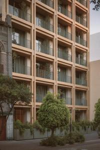 an apartment building with a tree in front of it at ONTO Alvaro Obregon Mexico City in Mexico City
