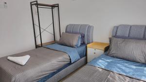 two beds sitting next to each other in a room at BaySuites Likas by Alawa Homes in Kota Kinabalu +26 photos