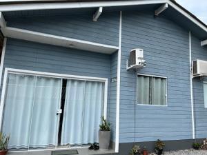 a blue house with a door and a window at Casa de Verão in Florianópolis