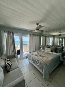 Un dormitorio con una cama y un sofá y una ventana. en Relaxing Galveston Oceanfront Escape With Heated Pool, en Galveston