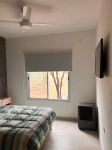 - une chambre avec un lit et une fenêtre avec une télévision dans l'établissement Casa Las Breas del Champaquí, à Las Tapias