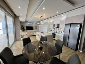 a kitchen and dining room with a glass table and chairs at Chequers Suites Subic Bay in Olongapo