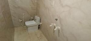 La salle de bains est pourvue de toilettes et d'un mur en marbre. dans l'établissement Shree Gopal seva sadan, à Mathura