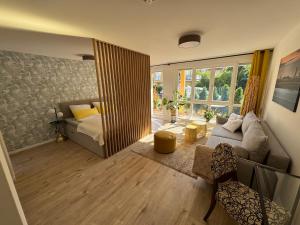 a living room with a couch and a bed in it at Gästeapartment am Agra Park 