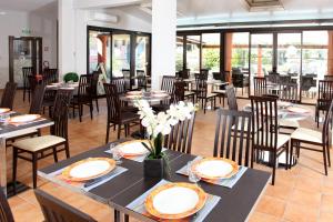 a dining room with tables and chairs and windows at Le Domaine du Thronnet in Figanières