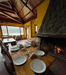 a dining room with a table and a fireplace at Hosteria y Restaurante Hua Hum in San Martín de los Andes