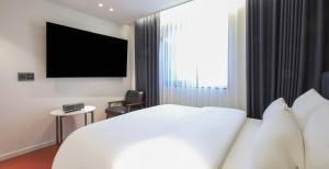 a hotel room with a bed and a large window at Labelle Hotel Premier in Gangneung