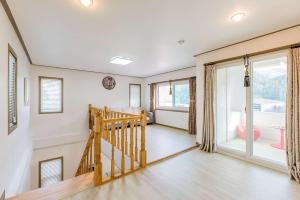 a living room with a staircase and a large window at Hue Bless Spa Pension Gapyeong in P'yŏngban-ni