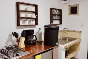 a kitchen with a counter top with a stove and a sink at El Portal de los Pasos in Antigua Guatemala