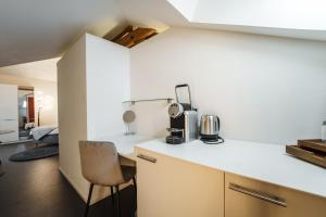 a kitchen with a counter and a chair in a room at Le Relais du Simplon in Sion