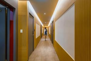 a woman walking down a hallway in a building at Gimhae Ubangdong JB hotel in Gimhae