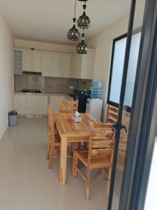 a kitchen with a wooden table and chairs at D'Bakis Private House in Ungasan