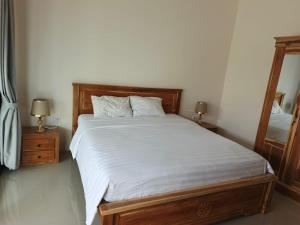 a bed in a bedroom with two lamps and a mirror at D'Bakis Private House in Ungasan