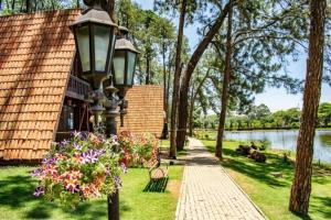 a park with a lamp post and flowers in the grass at Suíte das pétalas Holambra-SP in Holambra