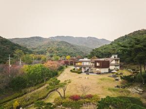 a house on a hill with mountains in the background at Seosan Soohwarim in Seosan