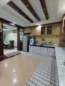 a large kitchen with a refrigerator and a table at Ujana Kingfisher double storey 3 Bedroom - Farah Biz Homestay in Kota Kinabalu