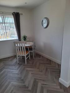 a dining room with a table and a clock on the wall at Florence House in Bradford