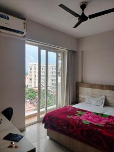 ein Schlafzimmer mit einem Bett und einem großen Fenster in der Unterkunft Hotel Mukund Vrindavan near Prem Mandir in Vrindāvan