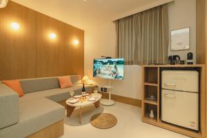a small living room with a couch and a tv at Hotel Daun Guri in Guri