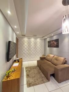 een woonkamer met een bank en een tv bij Recanto do Sol, 2 quartos, piscina ambiente tranquilo in Recife
