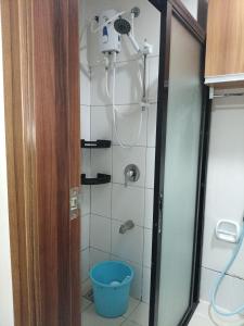 a shower with a blue bucket in a bathroom at Sky Horizon Hotel in Cebu City