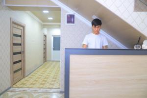 ein Mann, der mitten auf einem Dachboden steht in der Unterkunft GUEST HOUSE Silver1 in Samarkand