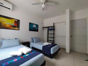 a bedroom with two beds and a closet at CasaMEXH Veredas - Tu refugio familiar entre la selva, cenotes y la playa, vive tus vacaciones lejos del turismo masivo, a 10 Min de la ruta de los cenotes y el arrecife más cercano de la Riviera Maya - A 20 min de Cancún y Playa del Carmen in Puerto Morelos +40 photos