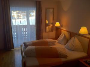 a hotel room with two beds and a window at Hotel Serena in Selva di Val Gardena