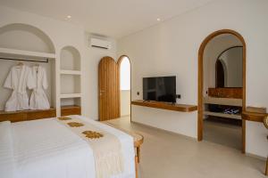 a bedroom with a bed and a flat screen tv at MarenaSol Villa Bingin, 1 BR Luxury Private Villa in Uluwatu