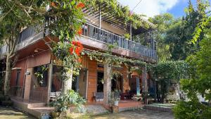 Malá home & coffee في دالات: مبنى مع شرفة مع الزهور الحمراء